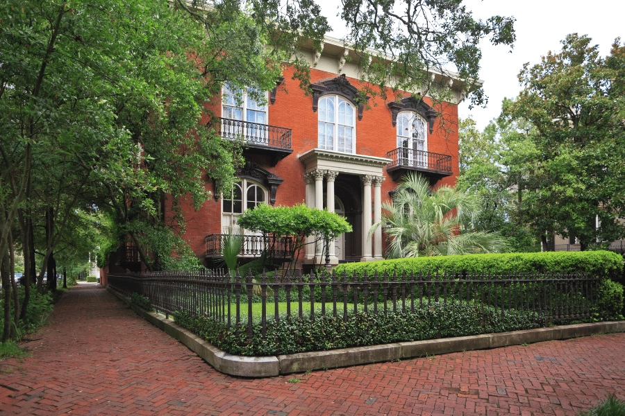 beautiful historic home with balconies and fenced in front yard